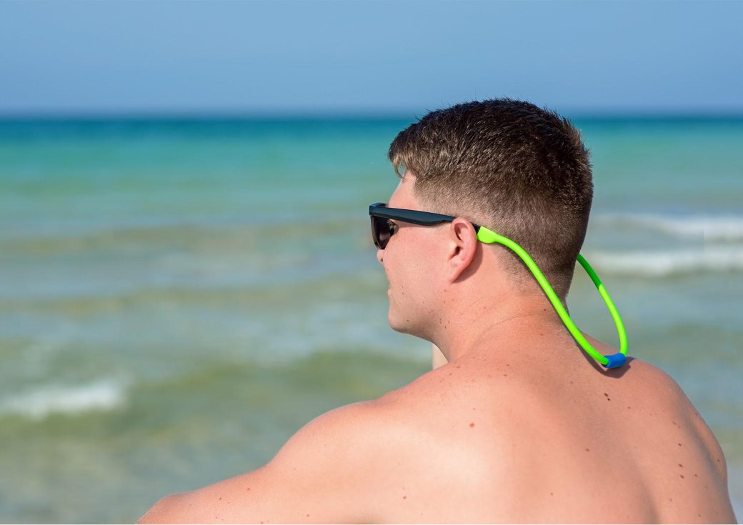 FLOTEZ on sunglasses worn by a guy at the beach